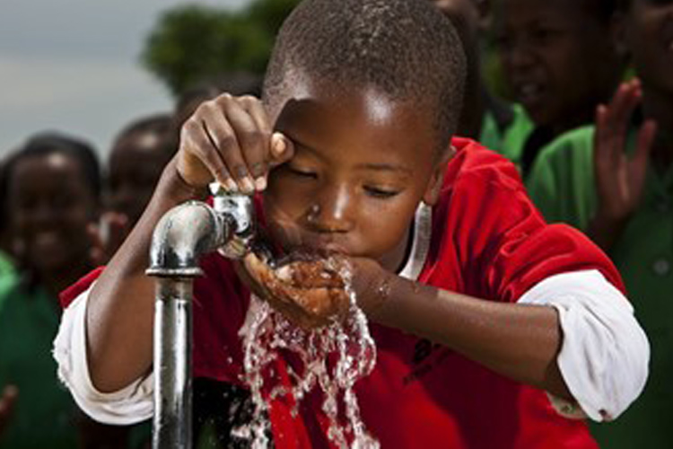 African child drinking from a tap