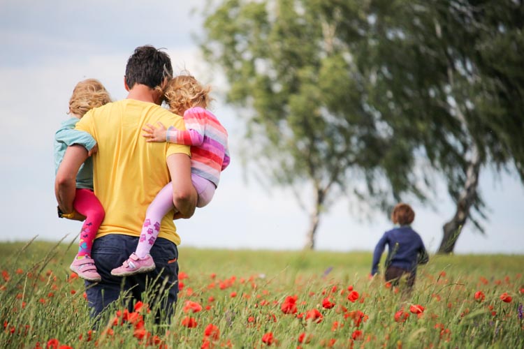 Father with children walking in the fields